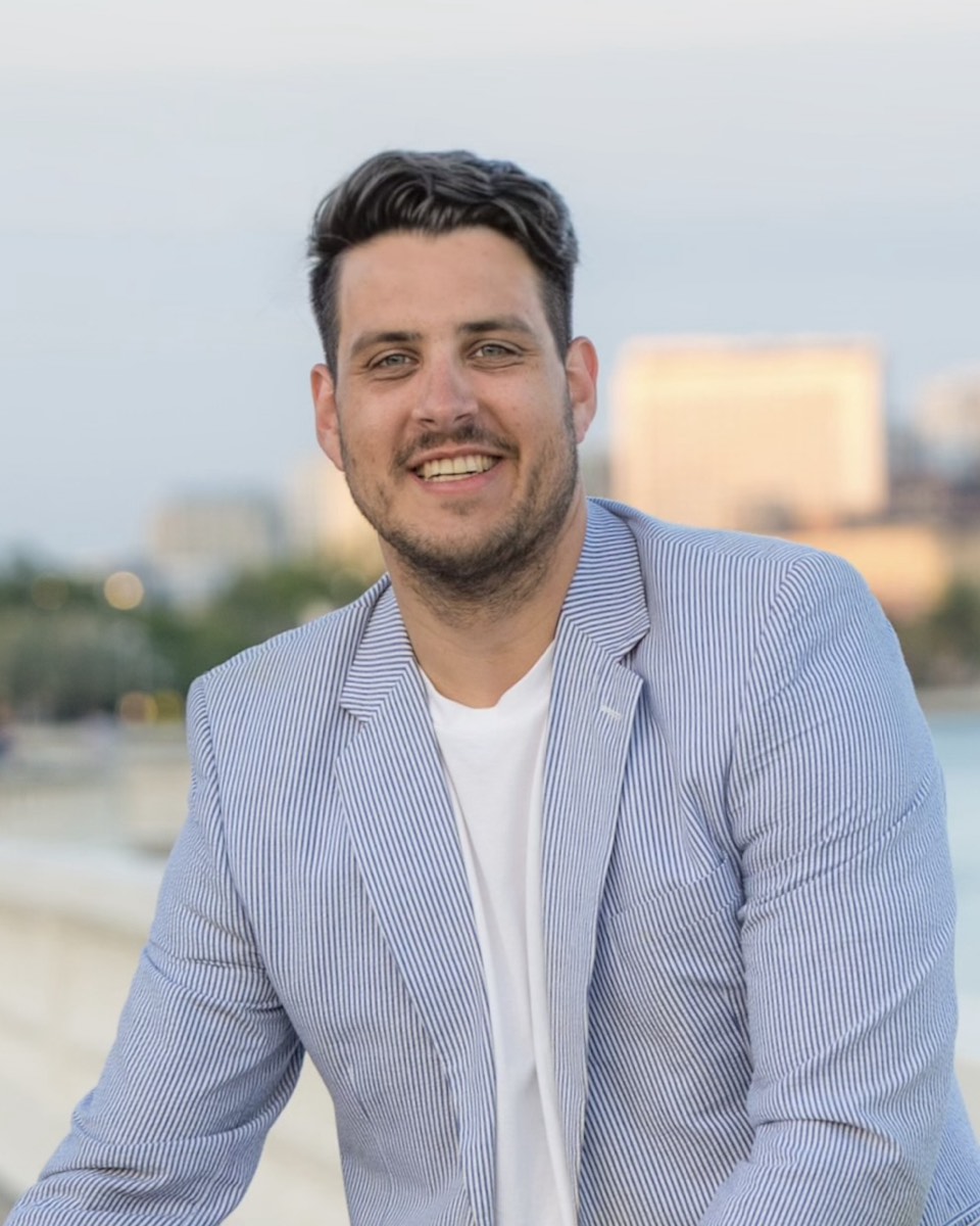 Asher Hamilton, navy blazer, looking like he just found money leaking out of a spreadsheet